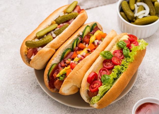 Foto gratuita perros calientes deliciosos de alto ángulo en placa