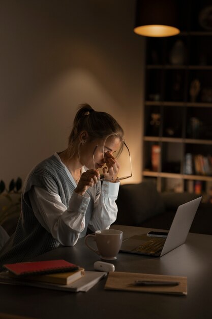 Persona adulta que trabaja en la computadora de casa por la noche