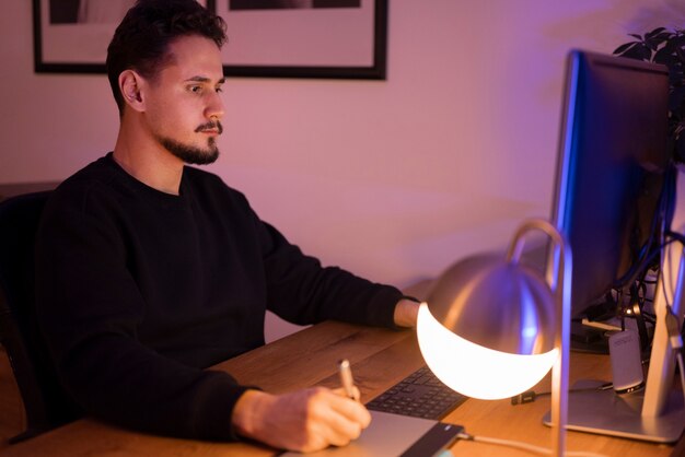 Persona adulta que trabaja tarde en la noche desde casa