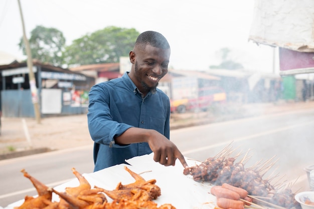 Persona africana obteniendo algo de comida en la calle