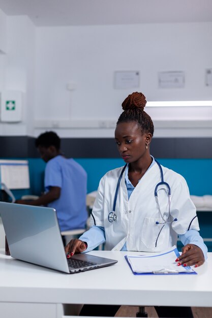 Persona afroamericana con trabajo médico usando laptop