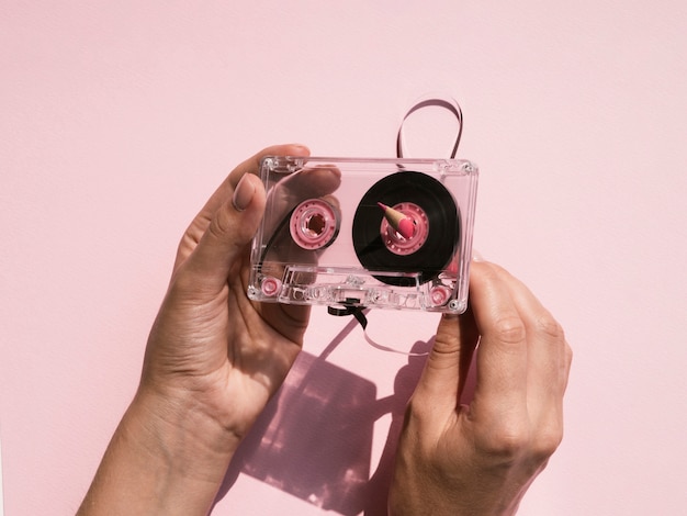 Foto gratuita persona arreglando cinta de cassette transparente