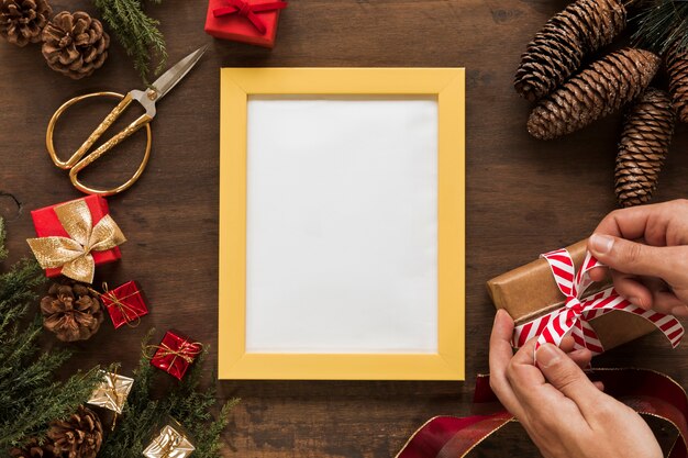 Persona atar arco en caja de regalo en mesa