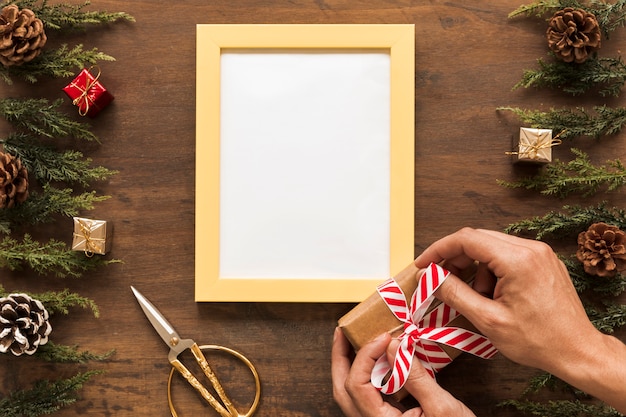 Persona atar arco en caja de regalo de Navidad