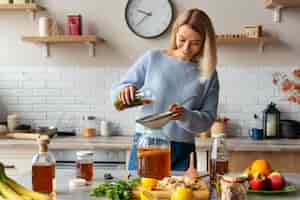 Foto gratuita persona bebiendo kombucha en casa en la cocina