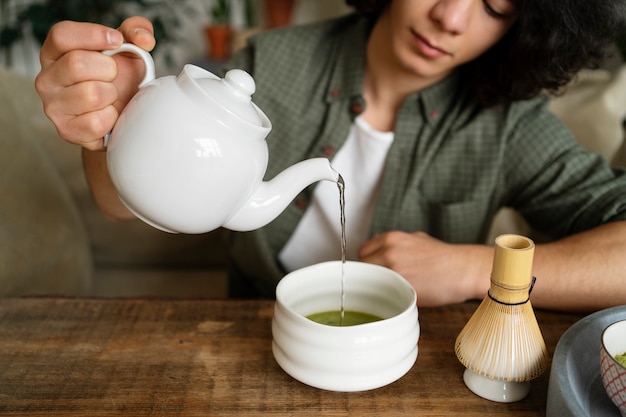 Foto gratuita persona bebiendo té matcha saludable