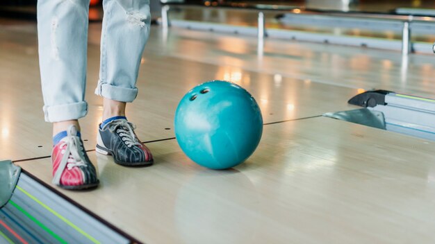 Persona y bola de boliche en la sala de bolos