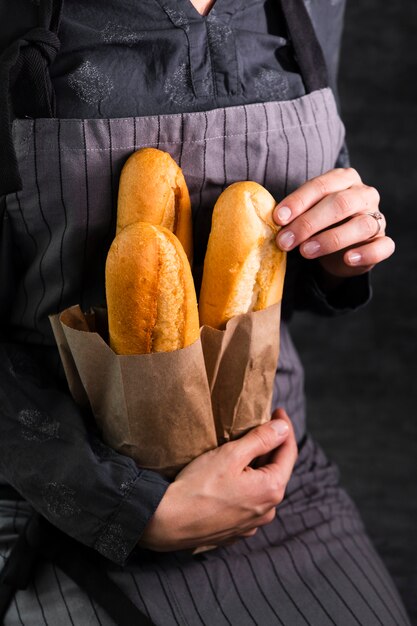 Persona con bolsa con baguettes frescas