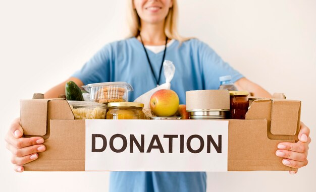 Persona con caja de donación con comida