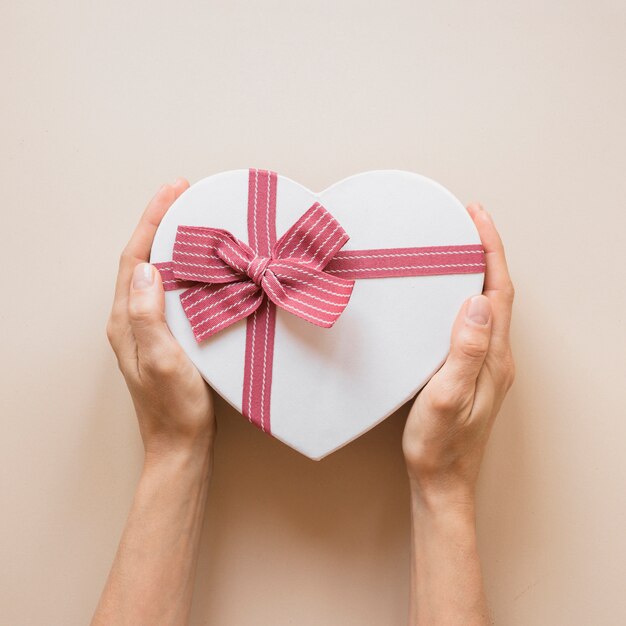 Persona con caja de regalo en forma de corazón