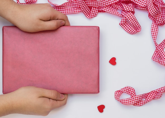 Persona con caja de regalo en mesa