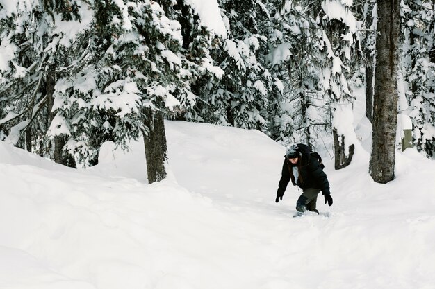 Persona caminando en el bosque nevado