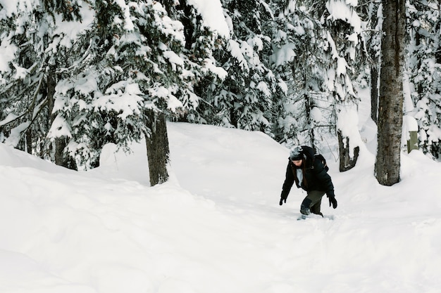 Persona caminando en el bosque nevado