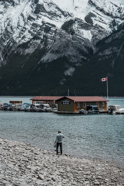 Persona caminando cerca de la orilla del mar viendo casas y montañas