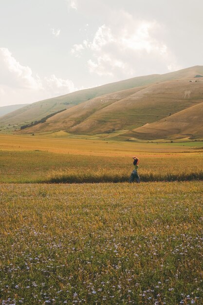 Persona caminando sobre campo verde y marrón