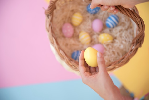 Persona con canasta con huevos de pascua