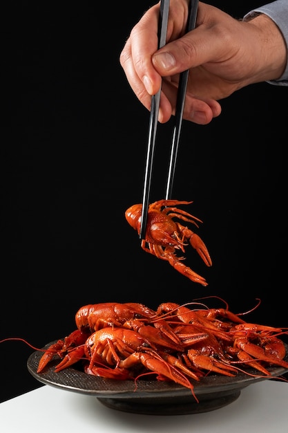 Persona comiendo langosta con palillos