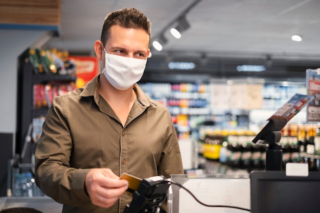 Foto gratuita persona comprando con mascarilla