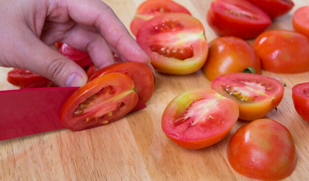 Persona cortando tomates en rodajas