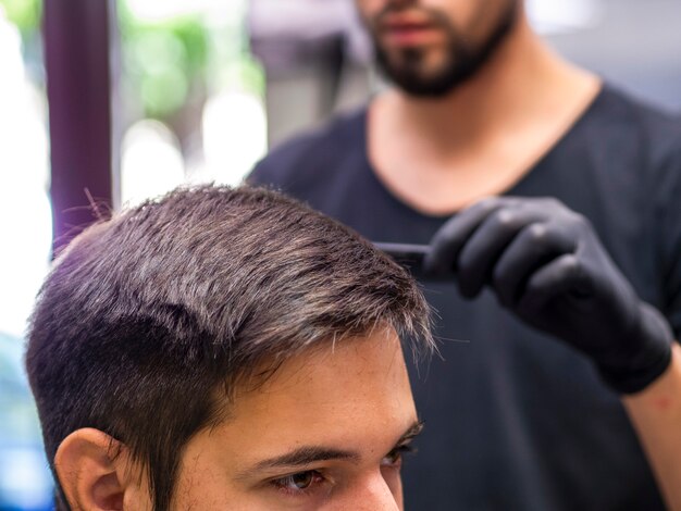 Persona cortarse el pelo con peluquería borrosa