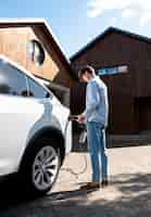 Foto gratuita persona cuidando coche eléctrico.