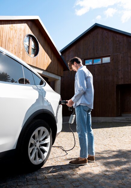 Persona cuidando coche eléctrico.