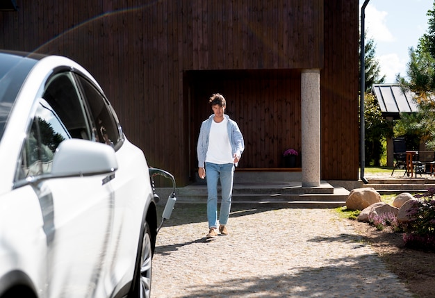 Foto gratuita persona cuidando coche eléctrico.