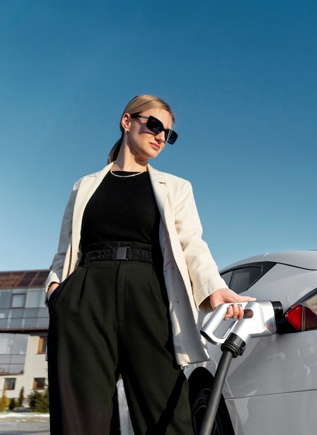 Foto gratuita persona cuidando coche eléctrico.