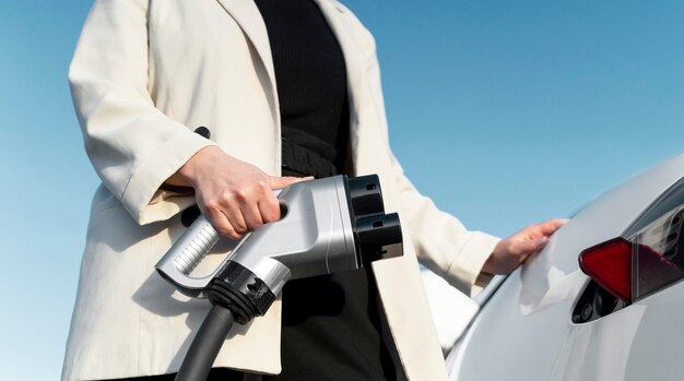 Persona cuidando coche eléctrico.