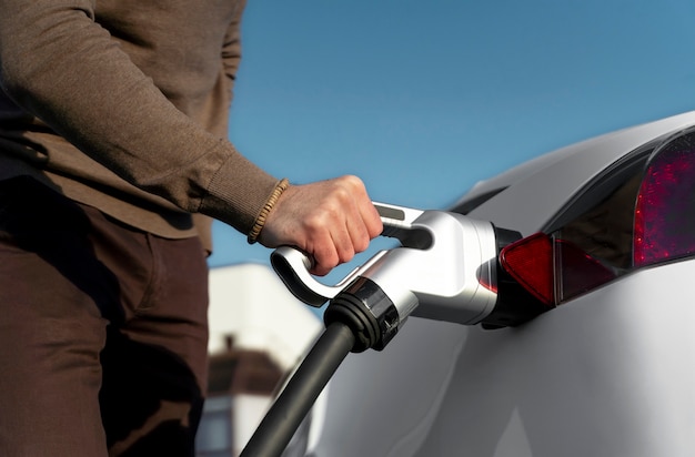 Persona cuidando coche eléctrico.