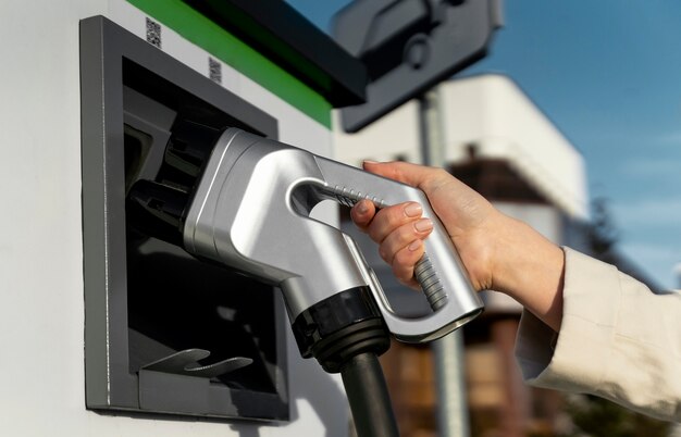 Persona cuidando coche eléctrico.