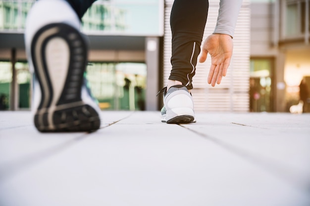 Persona de cultivo preparándose para correr en la calle