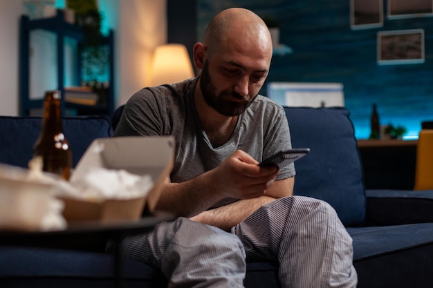 Foto gratuita persona desesperada y frustrada que navega por internet con smartphones, tratando de curar las dificultades de las enfermedades mentales y los pensamientos suicidas. hombre triste y ansioso con depresión crónica usando un dispositivo móvil.