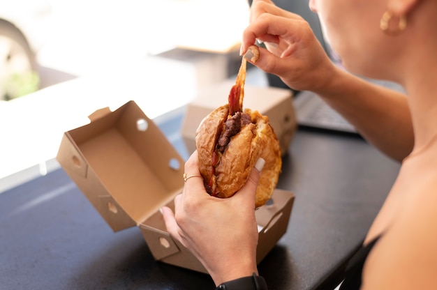 Persona disfrutando de una hamburguesa para llevar