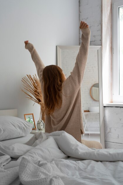 Persona en dormitorio con decoración de cama.