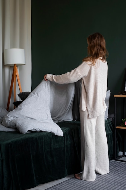 Persona en dormitorio con decoración de cama.