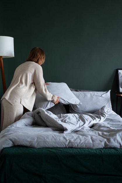 Persona en dormitorio con decoración de cama.