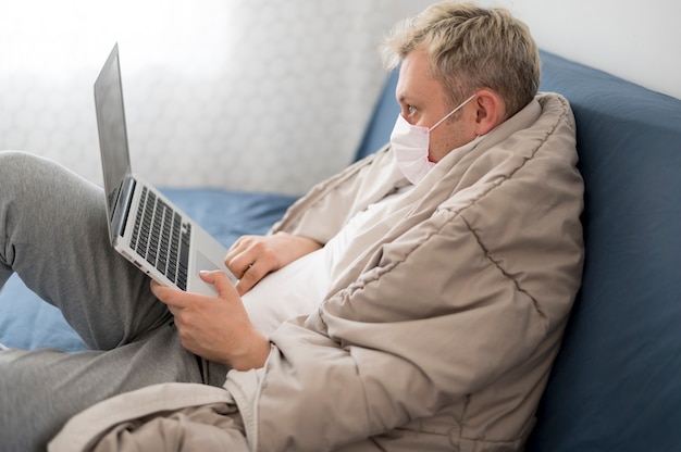 Persona enferma envuelta en una manta trabajando