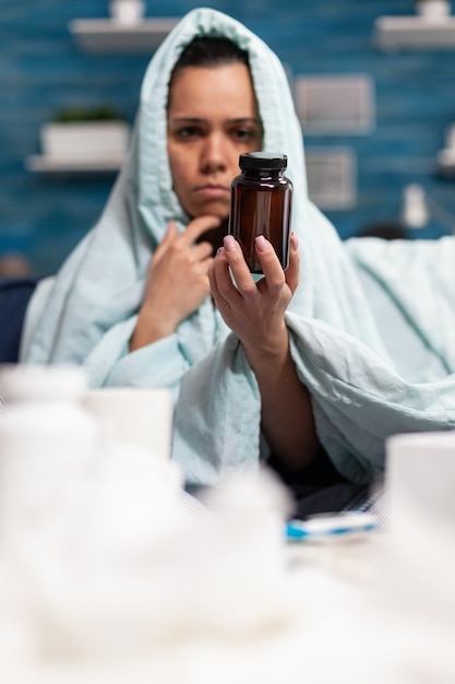 Persona con enfermedad sosteniendo una botella de cápsulas