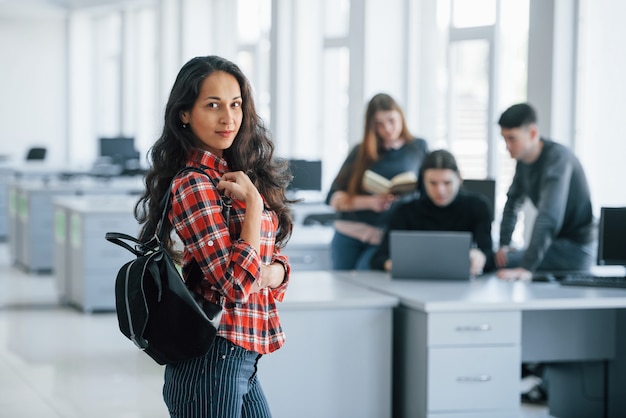 Una persona enfocada. Grupo de jóvenes en ropa casual que trabajan en la oficina moderna