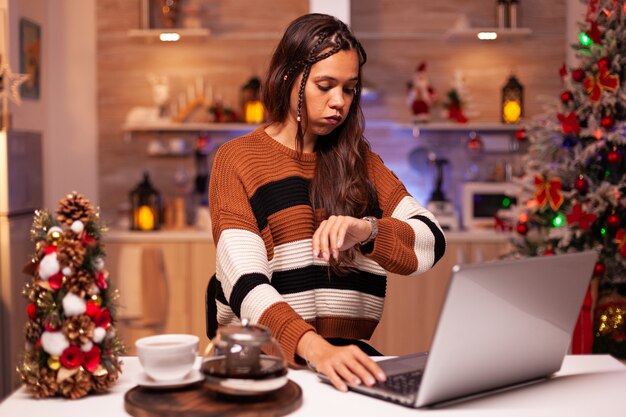 Persona enojada trabajando en la noche de Nochebuena usando laptop