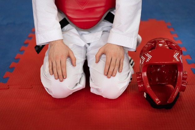 Foto gratuita persona con equipo de protección practicando taekwondo en un gimnasio