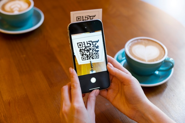 Persona escaneando código qr en la cafetería