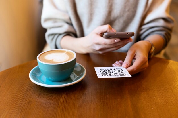 Persona escaneando código qr en la cafetería