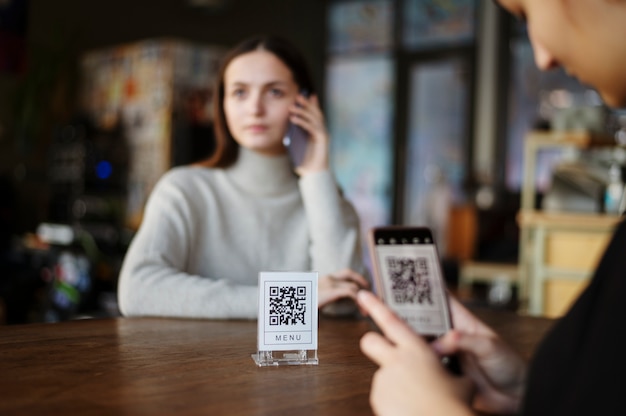 Persona escaneando código qr en la cafetería