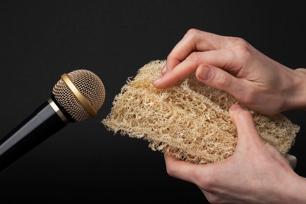 Persona con esponja vegetal cerca del micrófono para asmr