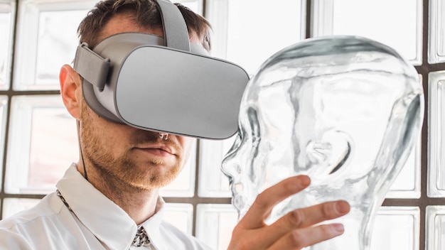 Persona con gafas de realidad virtual con un maniquí transparente