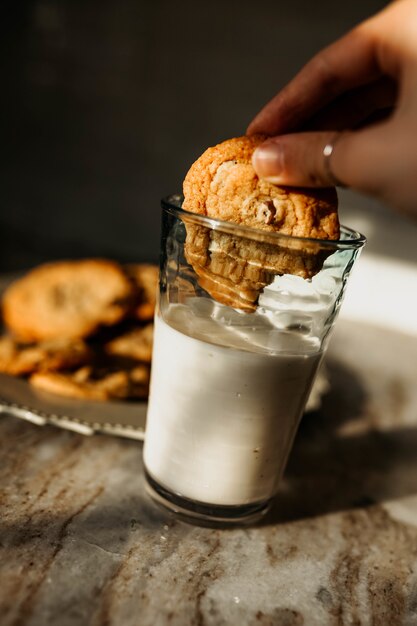 Persona con galletas en la leche