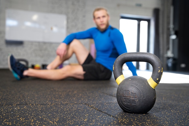 Persona en el gimnasio deportivo usando pesas rusas