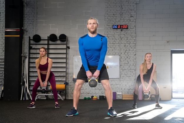 Persona en el gimnasio deportivo usando pesas rusas